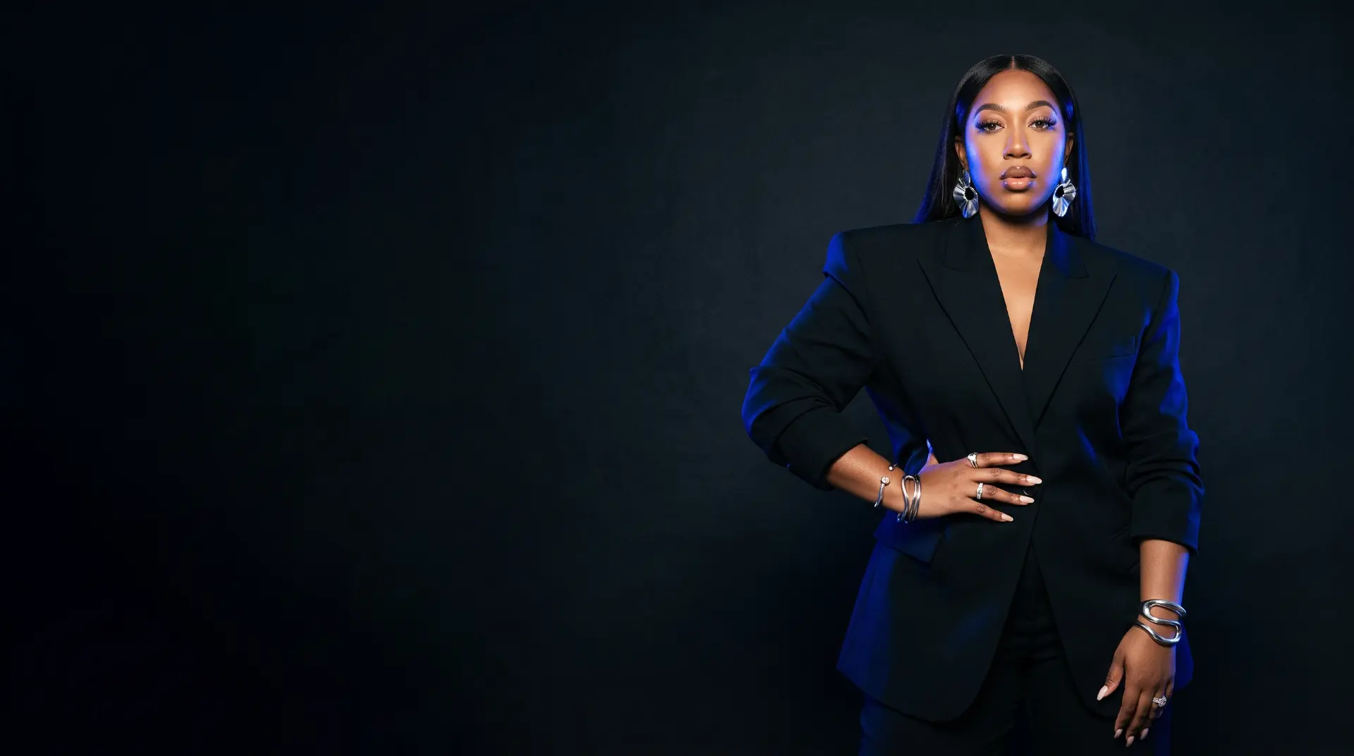 Kendah Parris in a black suit with cobalt studio lighting